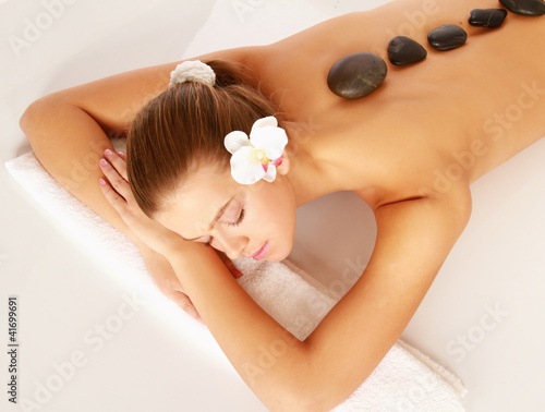 Photo: A beautiful woman relaxing in a spa center, isolated on white A beautiful woman relaxing in a spa center, isolated on white