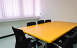 Small meeting room with wooden table and black chairs