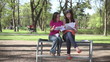 Two happy female students throwing papers away, slow motion