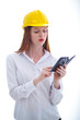 Photo: Young beautiful female with yellow helmet using a cellphone Young beautiful female with yellow helmet using a cellphone