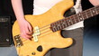 Close-up of female hand, playing the bass guitar