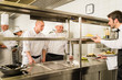 Restaurant waiter take meal from professional cook
