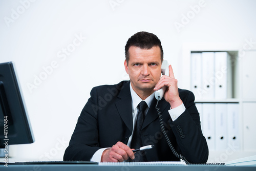 Photo: geschäftsmann mit ernsthaften blick am telefon geschäftsmann mit ernsthaften blick am telefon