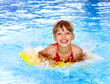 Child swimming on inflatable beach mattress.