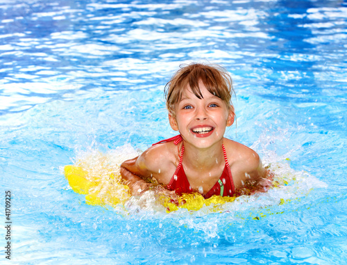 Photo: Child swimming on inflatable beach mattress. Child swimming on inflatable beach mattress.