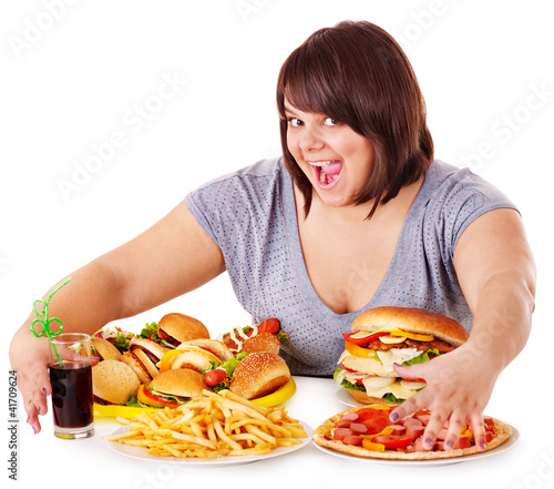 Photo: Woman eating fast food. Woman eating fast food.