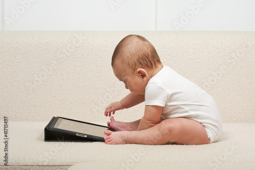 Photo: Baby with a small computer Baby with a small computer