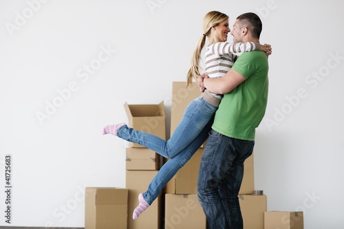 Photo: Young couple moving in new house Young couple moving in new house
