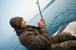 Photo: Fisher holds trolling rod Fisher holds trolling rod