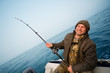 Fisher holds trolling rod. Focus on the right hand.