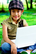 Cute girl sitting in the park with laptop