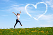 Foto: happy jumping girl with drawn heart against blue sky happy jumping girl with drawn heart against blue sky