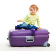 Kid sit on the big suitcase