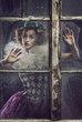 A lonely pierrot woman behind the glass