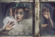 Foto: A lonely sad pierrot woman behind the glass A lonely sad pierrot woman behind the glass