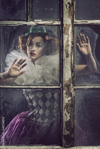 Foto: A lonely pierrot woman behind the glass A lonely pierrot woman behind the glass