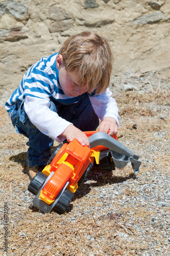 Photo: little boy playing with plastic toy little boy playing with plastic toy