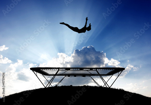 Illustration: silhouette of female gymnast on trampoline in sky silhouette of female gymnast on trampoline in sky