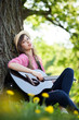 Young woman playing guitar in park