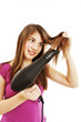 Beautiful smiling young woman drying her hair with drier