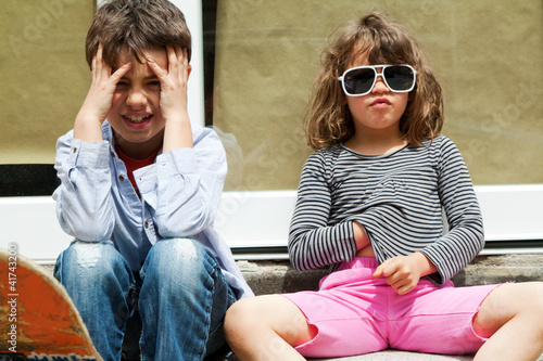 Photo: Brother an sister sitting in front of the door Brother an sister sitting in front of the door