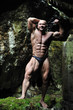 Young bodybuilder posing in a cave - Front view