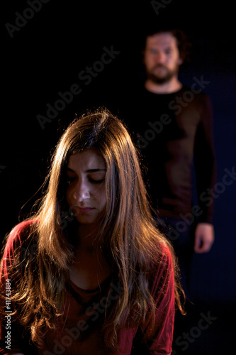 Photo: Sad woman oppressed by dark man Sad woman oppressed by dark man