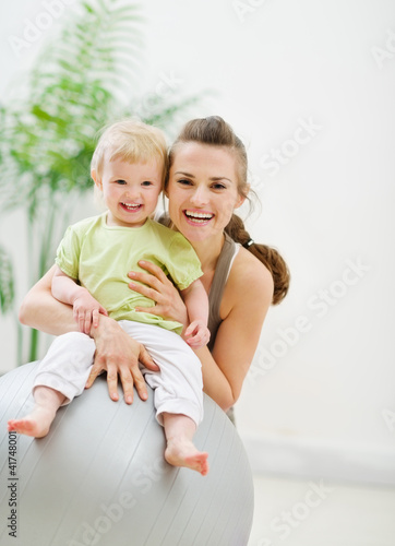 Photo: Portrait of happy mother and baby in gym Portrait of happy mother and baby in gym