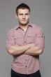 Portrait of pensive young handsome guy over gray background