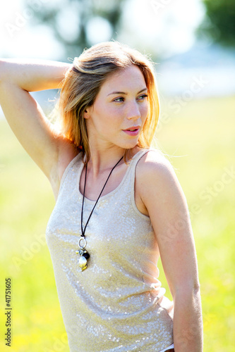 Photo: Beautiful blond woman standing in meadow with modern look Beautiful blond woman standing in meadow with modern look