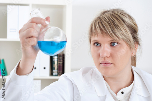 Photo: female chemist mixing liquids in test tubes female chemist mixing liquids in test tubes