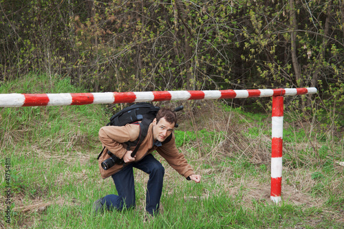 Photo: A young man passes under the barrier A young man passes under the barrier