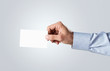 Photo: Male hand passing blank business card with copy space Male hand passing blank business card with copy space