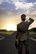 young businessman in front of a crossroad
