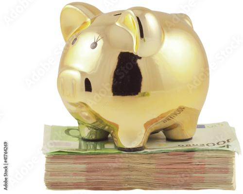 Foto: tirelire petit cochon doré sur liasse de billets tirelire petit cochon doré sur liasse de billets