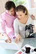 Couple at home looking at pictures on camera and laptop Couple at home looking at pictures on camera and laptop