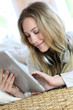 Young modern girl listening to music with electronic tablet