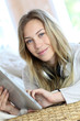 Young modern girl listening to music with electronic tablet
