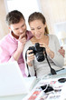 Couple at home looking at pictures on camera and laptop