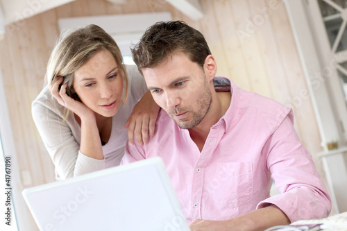 Photo: Couple at home using laptop computer Couple at home using laptop computer