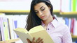 smiling female student reading a book in a bookstore