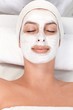 Young woman with facial mask eyes closed