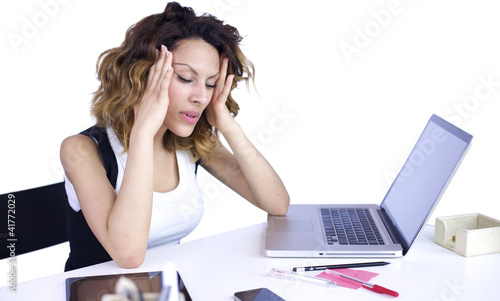 Photo: Woman with headache at the desk Woman with headache at the desk