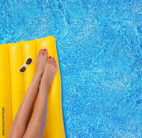 Photo: Woman relaxing in a pool - feet close up Woman relaxing in a pool - feet close up