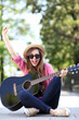 Young woman playing guitar outdoors