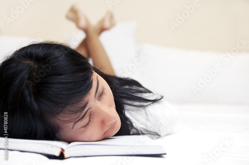 Photo: Tired woman reading a book Tired woman reading a book