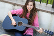 Young woman sitting with a guitar