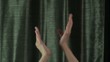 clapping on green curtain