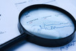 magnifying glass over financial newspaper