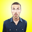 young man looking up over yellow background young man looking up over yellow background